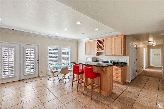 2010 E Rocklin Dr, Sandy, UT 84092 - kitchen with light brown cabinetry, a kitchen breakfast bar, dark countertops, ornamental molding, and light tile patterned flooring