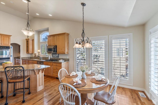 2010 E Rocklin Dr, Sandy, UT 84092 - dining area featuring plenty of natural light, lofted ceiling, visible vents, and light wood-type flooring
