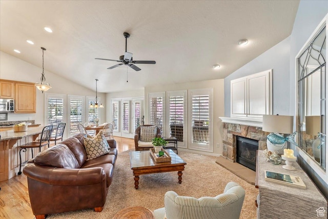 2010 E Rocklin Dr, Sandy, UT 84092 - living area with lofted ceiling, a stone fireplace, light wood-type flooring, and ceiling fan