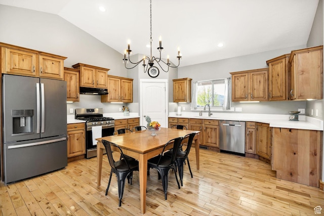 kitchen featuring light wood-style flooring, a sink, a chandelier, brown cabinetry, and appliances with stainless steel finishes