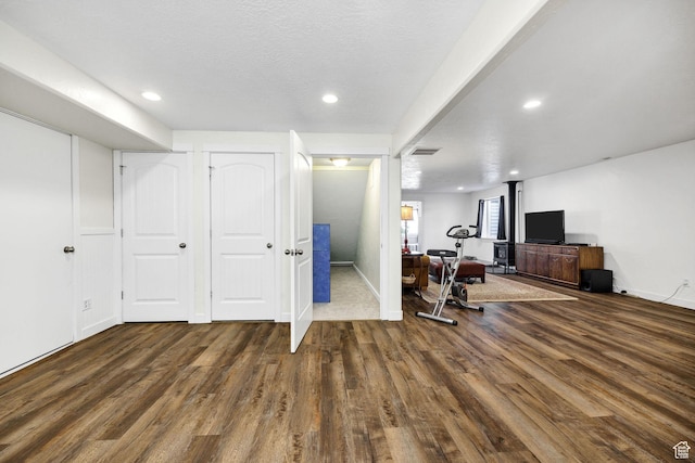 exercise area featuring baseboards, wood finished floors, visible vents, and recessed lighting