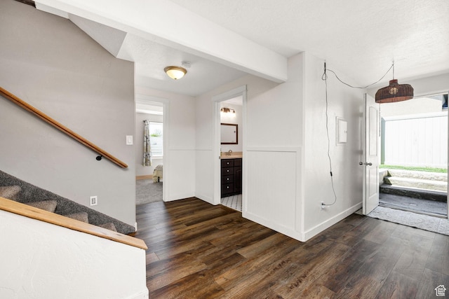 foyer featuring baseboards, stairs, and dark wood finished floors