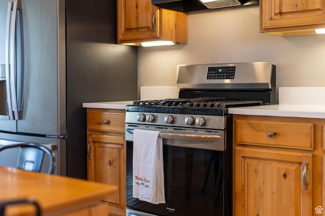 kitchen featuring brown cabinets, stainless steel appliances, light countertops, and ventilation hood