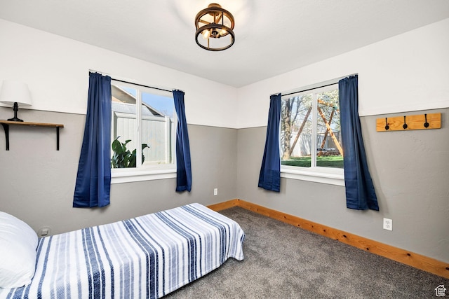 carpeted bedroom featuring baseboards and multiple windows