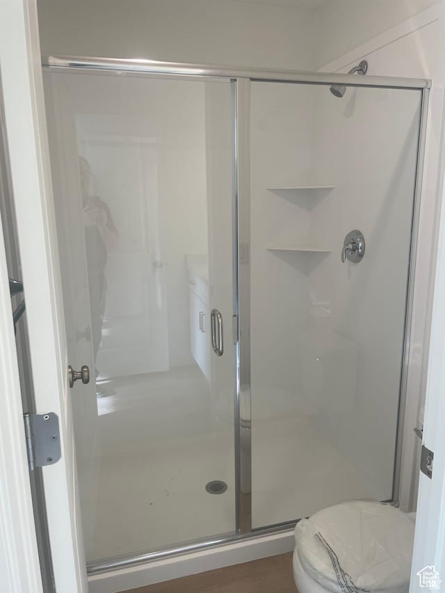 full bath featuring a shower stall and toilet