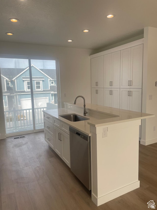kitchen with white cabinets, stainless steel dishwasher, wood finished floors, and a sink