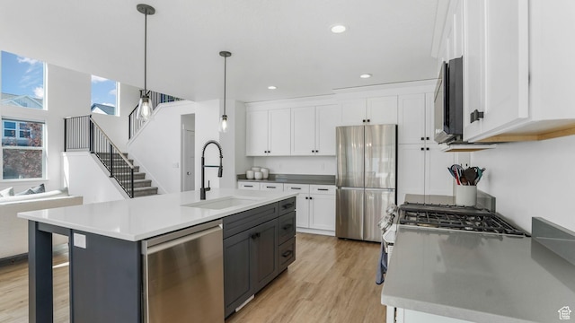 12373 S Pedroia St, Herriman, UT 84096 - kitchen with stainless steel appliances, a sink, white cabinets, light wood-type flooring, and recessed lighting