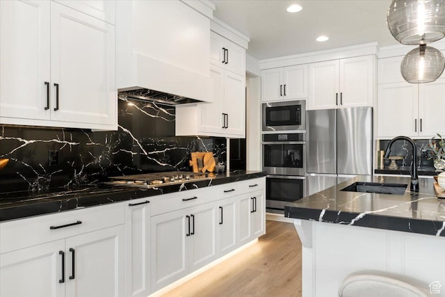 kitchen with a sink, white cabinets, backsplash, appliances with stainless steel finishes, and recessed lighting