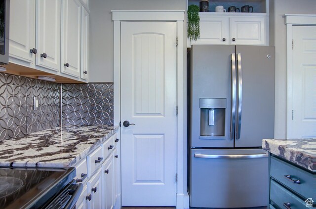 1896 N Main St, Orem, UT 84057 - kitchen with stainless steel fridge with ice dispenser, white cabinets, light stone countertops, and backsplash