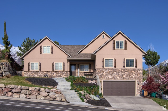 view of front of property with stone siding, driveway, a garage, and stucco siding