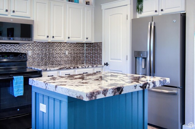 1896 N Main St, Orem, UT 84057 - kitchen featuring decorative backsplash, white cabinets, light stone countertops, and stainless steel appliances