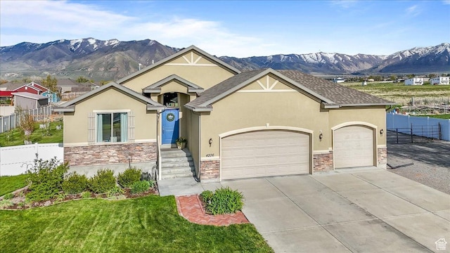 view of front of property featuring stone siding, fence, and a mountain view