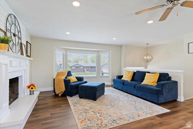 living room with recessed lighting, baseboards, dark wood-type flooring, and ceiling fan with notable chandelier