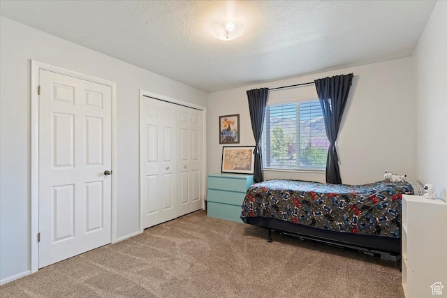 carpeted bedroom featuring a textured ceiling and a closet