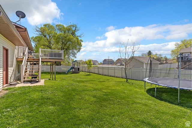 view of yard featuring stairway, a playground, a fenced backyard, a wooden deck, and a trampoline