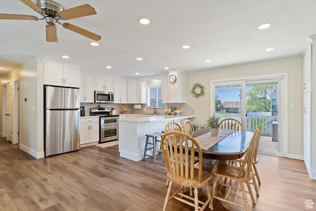 dining space with recessed lighting, wood finished floors, a ceiling fan, and baseboards