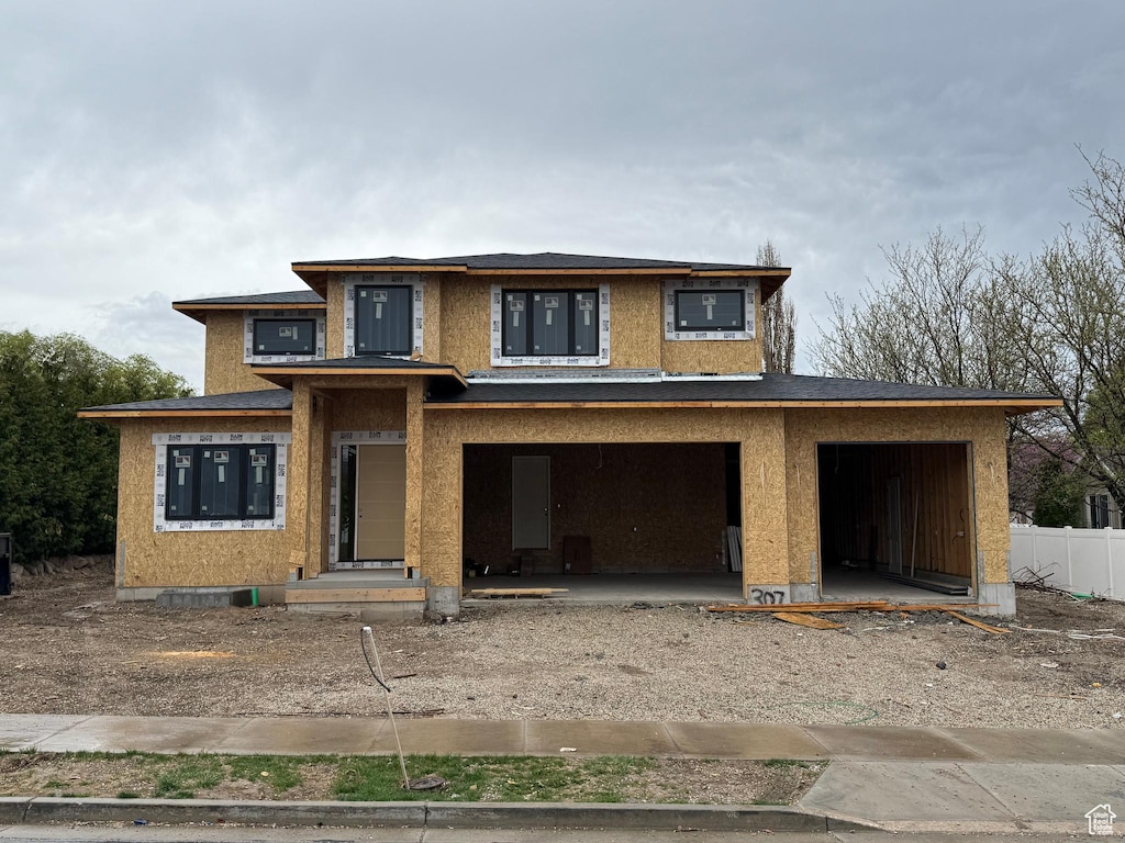 view of front of home featuring a garage, driveway, and fence