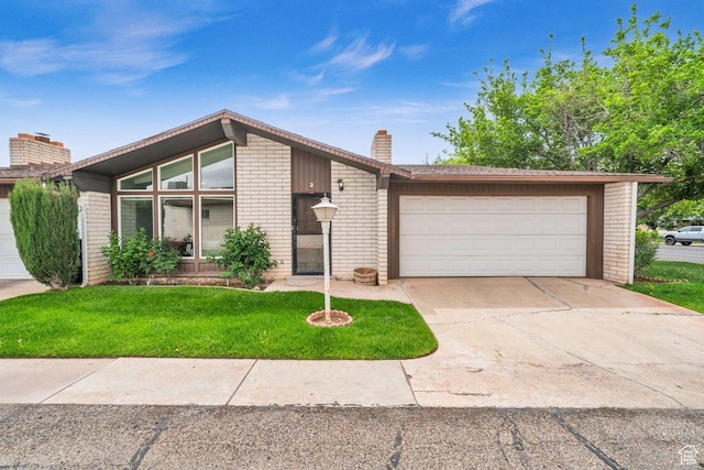 mid-century inspired home featuring a chimney, concrete driveway, an attached garage, a front yard, and brick siding