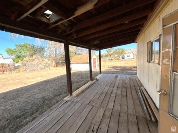 wooden terrace with a storage shed and an outbuilding