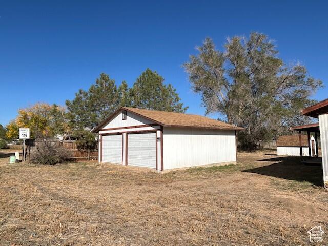 detached garage featuring fence
