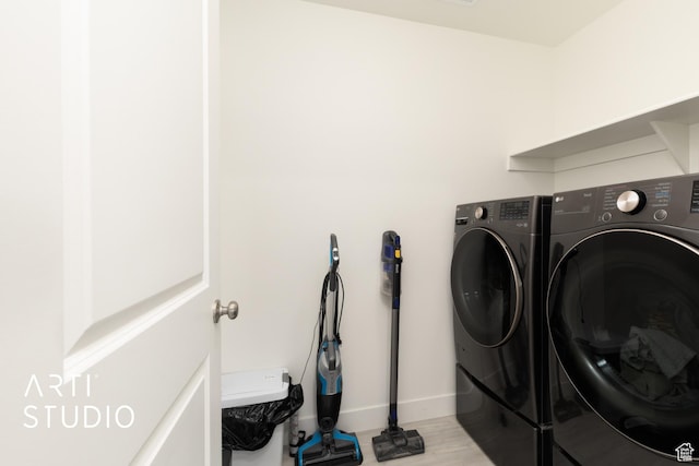 washroom featuring washing machine and dryer, light wood-style floors, baseboards, and laundry area