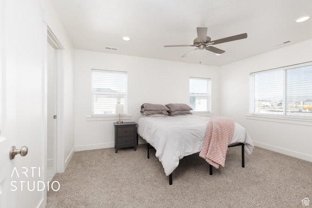 carpeted bedroom with baseboards, multiple windows, and visible vents