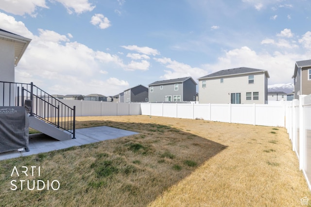 view of yard featuring a fenced backyard, a patio area, and a residential view