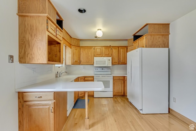2344 E Arnett Dr, Millcreek, UT 84109 - kitchen featuring a sink, white appliances, light wood-type flooring, light countertops, and a peninsula