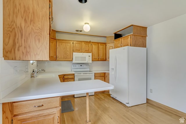 2344 E Arnett Dr, Millcreek, UT 84109 - kitchen with light countertops, a sink, white appliances, a peninsula, and light wood-style flooring