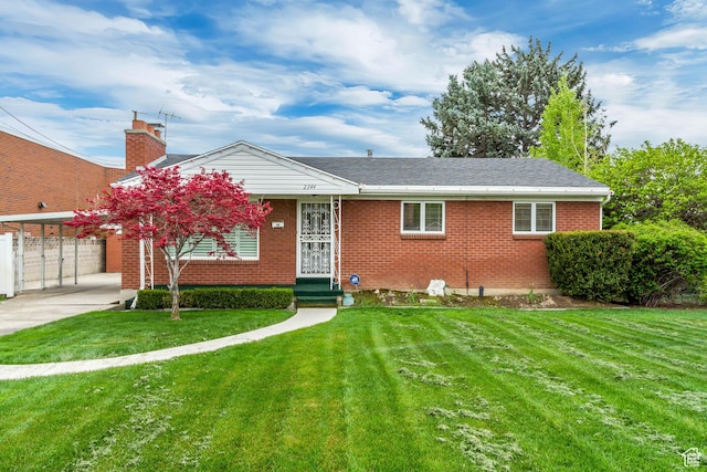 ranch-style home featuring a front lawn, brick siding, fence, and driveway