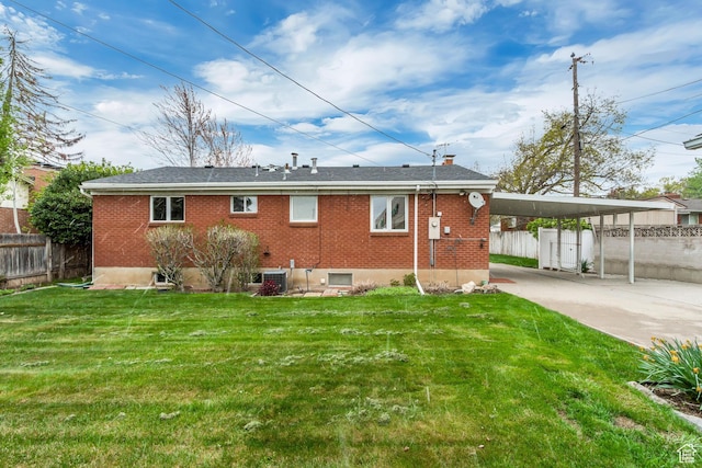 2344 E Arnett Dr, Millcreek, UT 84109 - back of property with an attached carport, driveway, fence, brick siding, and a yard