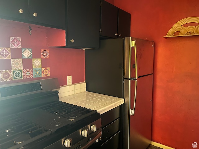 416 E Creekside Cir Unit C, Murray, UT 84107 - kitchen with dark cabinetry, stainless steel appliances, and tile counters