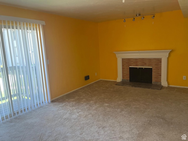 416 E Creekside Cir Unit C, Murray, UT 84107 - unfurnished living room featuring carpet flooring, rail lighting, a brick fireplace, and a wealth of natural light
