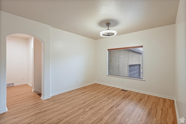 9226 N Mount Airey Dr W, Eagle Mountain, UT 84005 - spare room featuring arched walkways, light wood-style floors, and baseboards