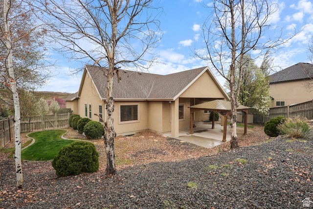 9226 N Mount Airey Dr W, Eagle Mountain, UT 84005 - back of house featuring stucco siding, a shingled roof, a patio, and a fenced backyard