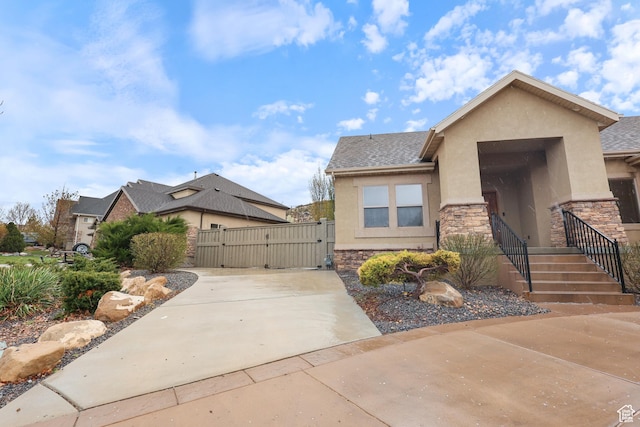 9226 N Mount Airey Dr W, Eagle Mountain, UT 84005 - view of front facade featuring a gate, stucco siding, and stone siding