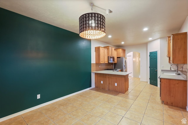 9226 N Mount Airey Dr W, Eagle Mountain, UT 84005 - kitchen with stainless steel appliances, arched walkways, a sink, a peninsula, and decorative backsplash