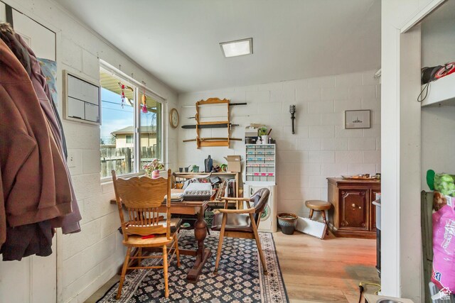 dining room with wood finished floors and concrete block wall