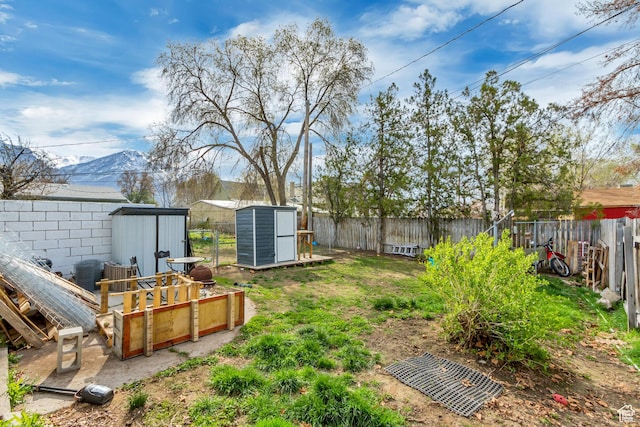 view of yard featuring a fenced backyard, an outdoor structure, and a storage shed