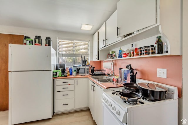 kitchen with open shelves, a sink, white appliances, light countertops, and white cabinetry
