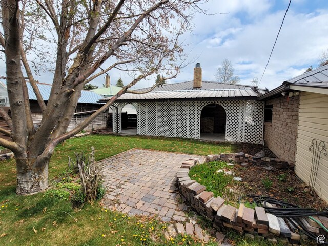 273 S 7th St S, Montpelier, ID 83254 - back of house with a chimney, a patio area, a metal roof, and brick siding