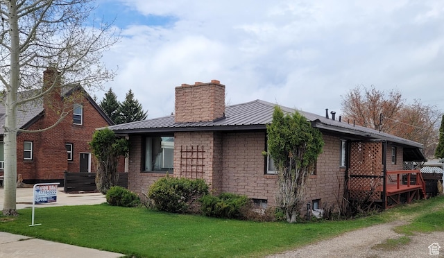 273 S 7th St S, Montpelier, ID 83254 - view of side of property with a chimney, a yard, a metal roof, and brick siding