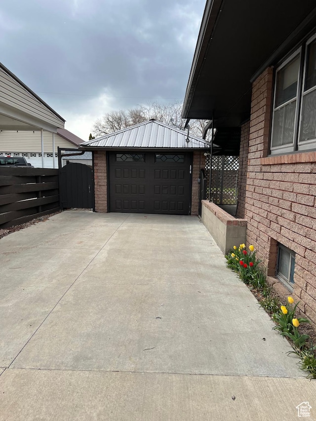 273 S 7th St S, Montpelier, ID 83254 - view of side of property with a detached garage, brick siding, fence, an outbuilding, and metal roof