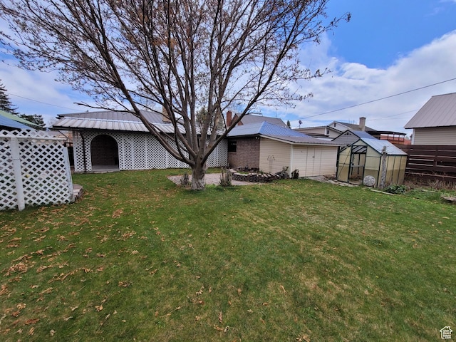 273 S 7th St S, Montpelier, ID 83254 - rear view of house with a greenhouse, an outbuilding, a chimney, and a metal roof