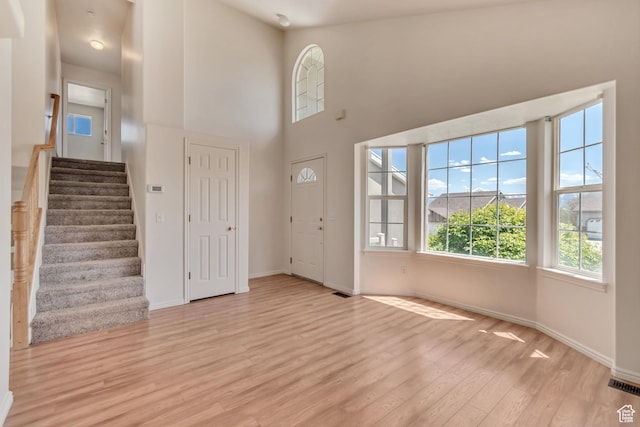 6706 S Adventure Way, West Jordan, UT 84084 - entrance foyer with stairs, visible vents, light wood-style flooring, a high ceiling, and baseboards