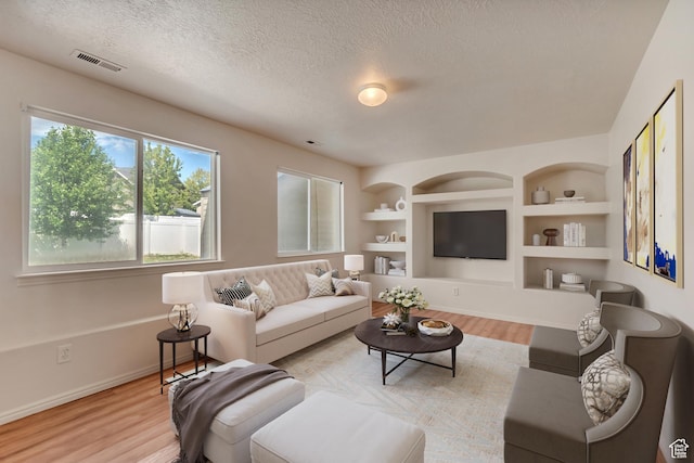 6706 S Adventure Way, West Jordan, UT 84084 - living area with a textured ceiling, wood finished floors, baseboards, and built in features