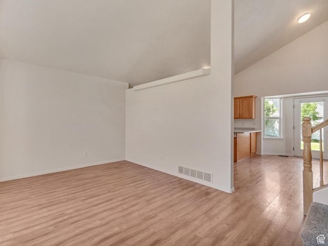 6706 S Adventure Way, West Jordan, UT 84084 - unfurnished living room with baseboards, light wood-style floors, visible vents, and high vaulted ceiling