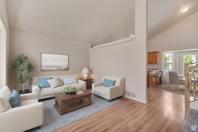 6706 S Adventure Way, West Jordan, UT 84084 - living area featuring light wood finished floors, high vaulted ceiling, and baseboards