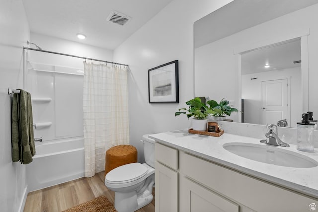 bathroom featuring wood finished floors, visible vents, toilet, vanity, and shower / bath combo