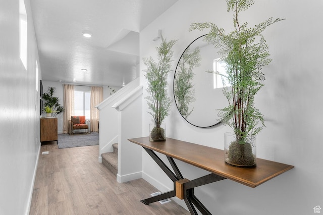 foyer entrance featuring stairway, baseboards, and wood finished floors
